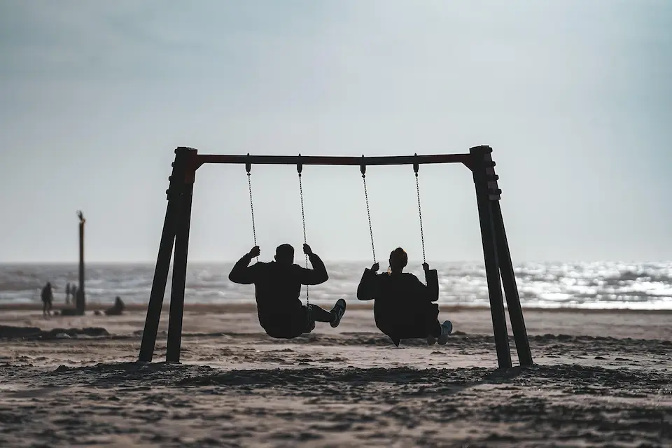 Two people talking on a porch swing, representing connection and belonging outside of achievement.