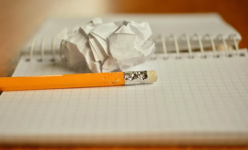 A hand erasing a to-do list, representing the exhausting cycle of perfectionism.